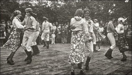 Fot. 2. Korowód dożynkowy w Śnieciskach, 1971. Na zdjęciu inscenizacja „siewu z płachty” w wykonaniu Franciszka Białkowskiego. W drugim rzędzie idą Marian Paterak i Stefania Andrzejewska. Źródło: Halina Błaszyk, Kronika zespołów tanecznych (1959-1987) w Śnieciskach (tekst niepublikowany).